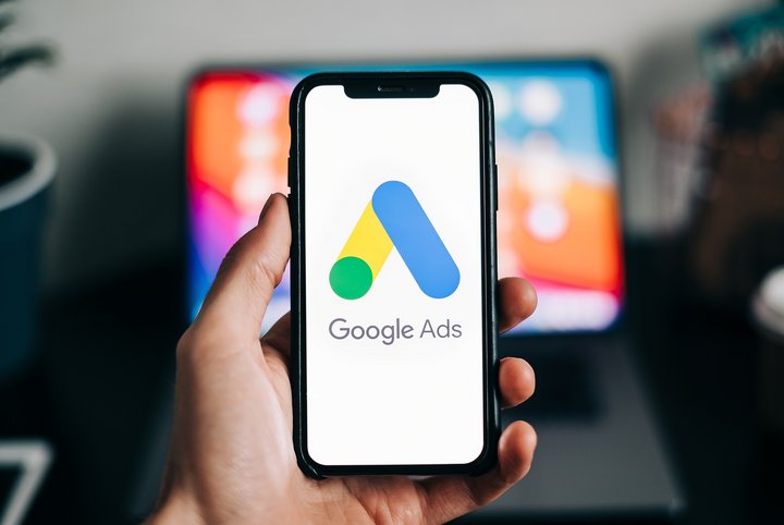 Learning how to master google ads for beginners and looking at Google Ads logo on smartphone screen in hand.